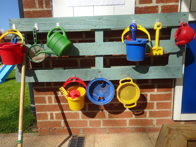 Buckets, watering cans and seives, ready for play in the sandpit.
